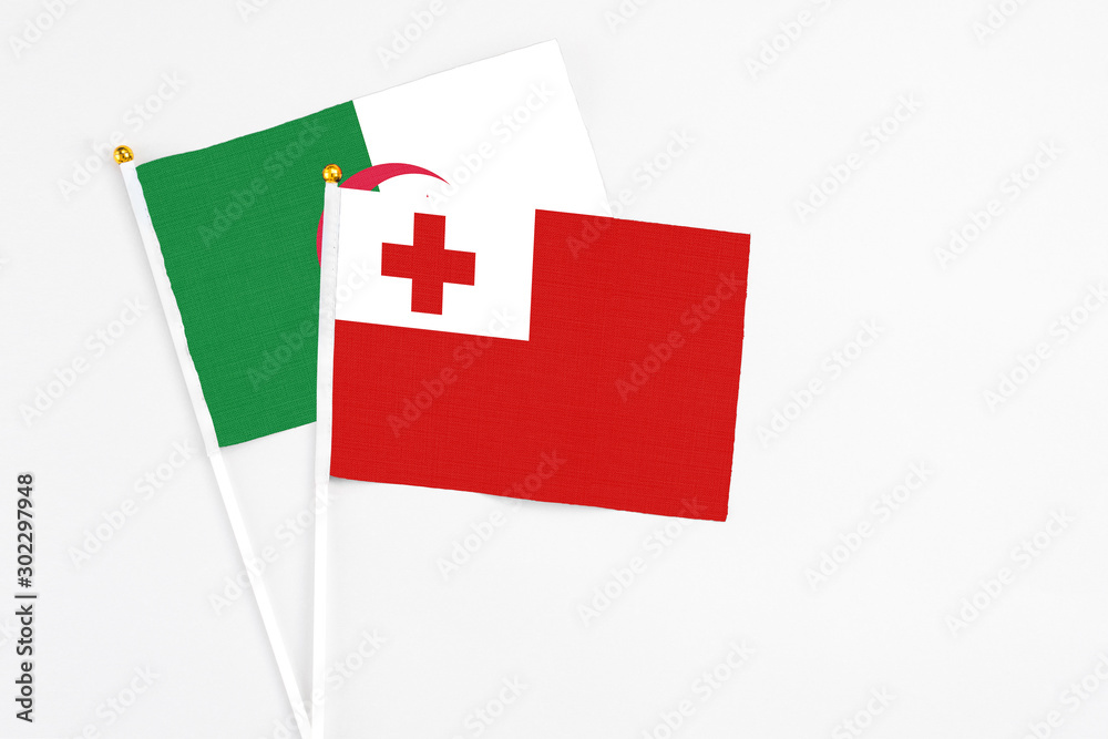 Tonga and Algeria stick flags on white background. High quality fabric, miniature national flag. Peaceful global concept.White floor for copy space.
