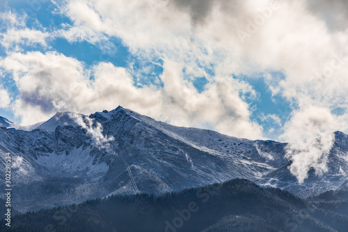 HDR photo of the Tatra Mountains and Great Giewont Peak with the steel Cross between clouds. © Konrad