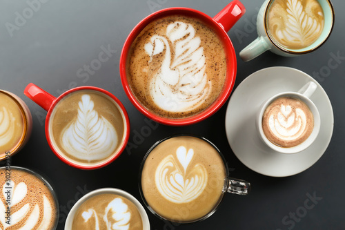 Buch of coffee cups with different kind of beverage and different latte art foam designs. Top view  close up  copy space  background.