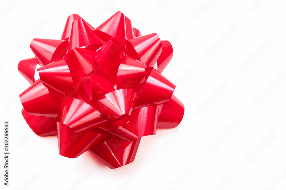 Voluminous gift bow in bright shiny red on white background Voluminous gift bow in bright shiny red on white background