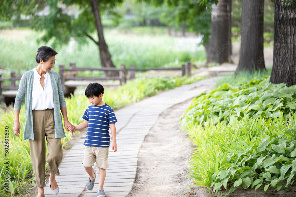 Happy Chinese grandmother and grandson walking in park Happy Chinese grandmother and grandson walking in park