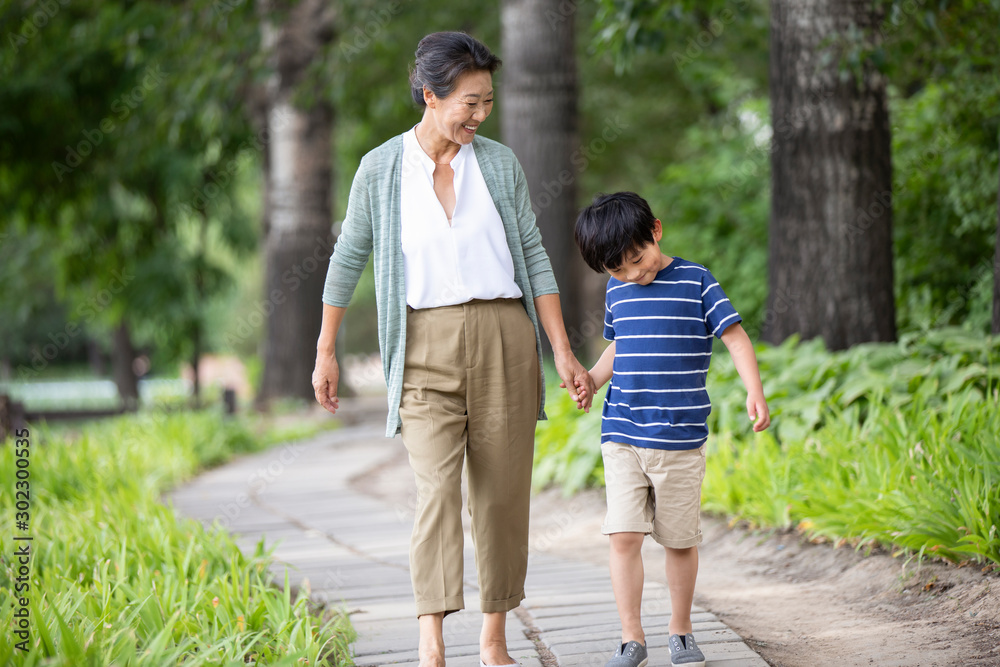 Happy Chinese grandmother and grandson walking in park Happy Chinese grandmother and grandson walking in park