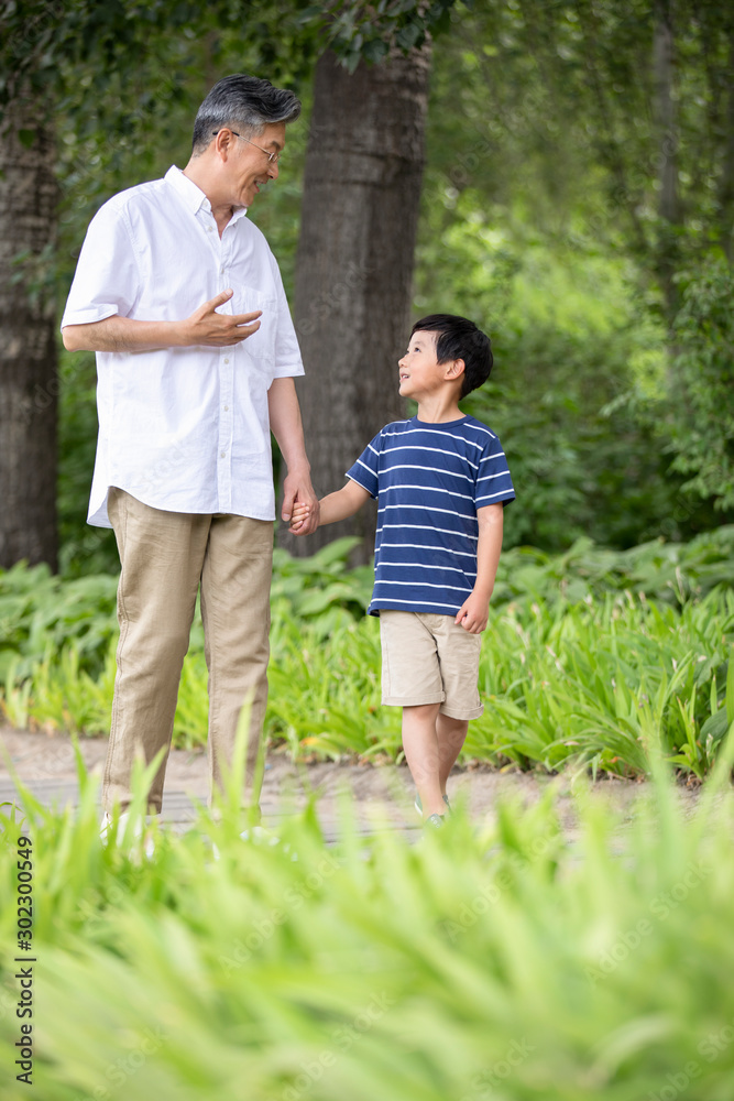 Happy Chinese grandfather and grandson walking in park Happy Chinese grandfather and grandson walking in park