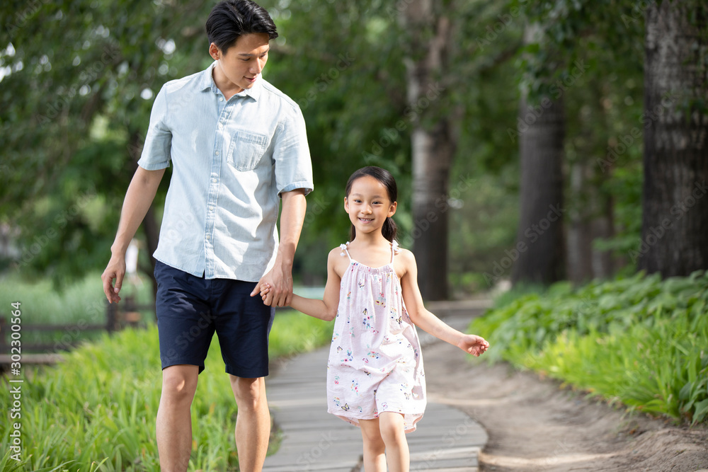 Happy Chinese father and daughter walking in park Happy Chinese father and daughter walking in park