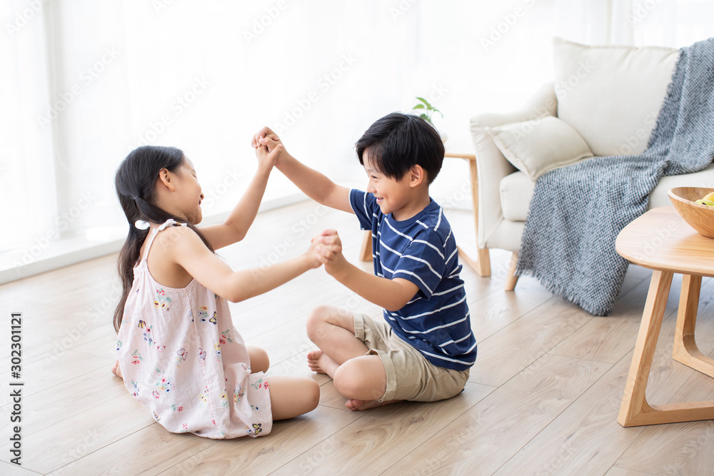 Happy Chinese sibling playing in living room Happy Chinese sibling playing in living room