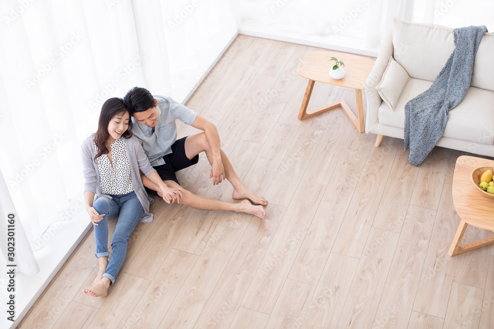 Happy young Chinese couple sitting on floor Happy young Chinese couple sitting on floor