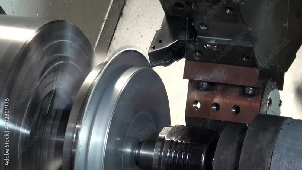 A machine spins a metal disk on itself, and another machine with a ...