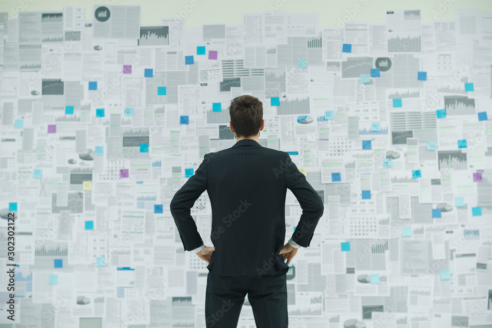 Confident businessman analyzing financial charts Confident businessman analyzing financial charts