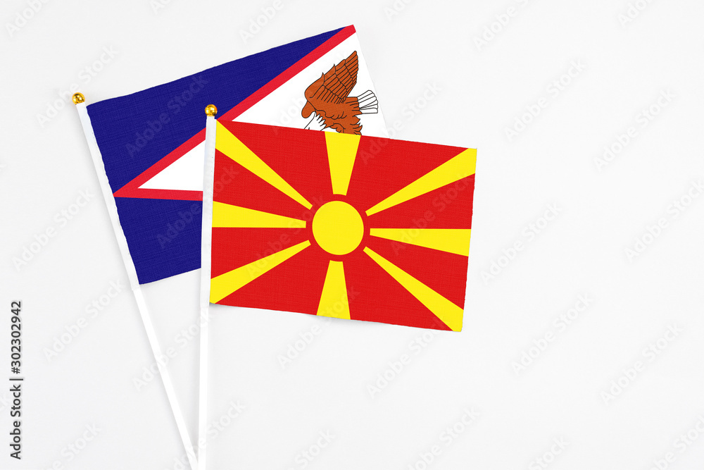 Macedonia and American Samoa stick flags on white background. High quality fabric, miniature national flag. Peaceful global concept.White floor for copy space.