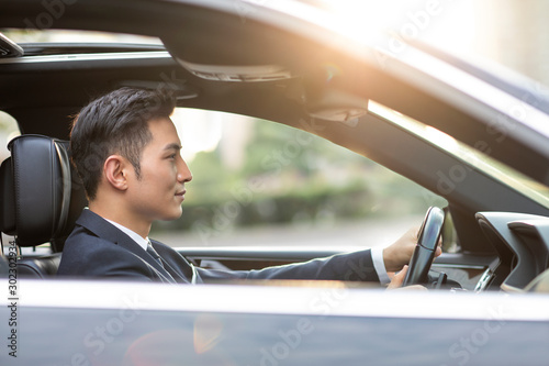 Confident businessman driving car