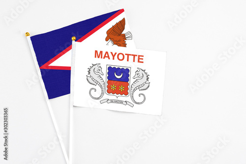 Mayotte and American Samoa stick flags on white background. High quality fabric, miniature national flag. Peaceful global concept.White floor for copy space.