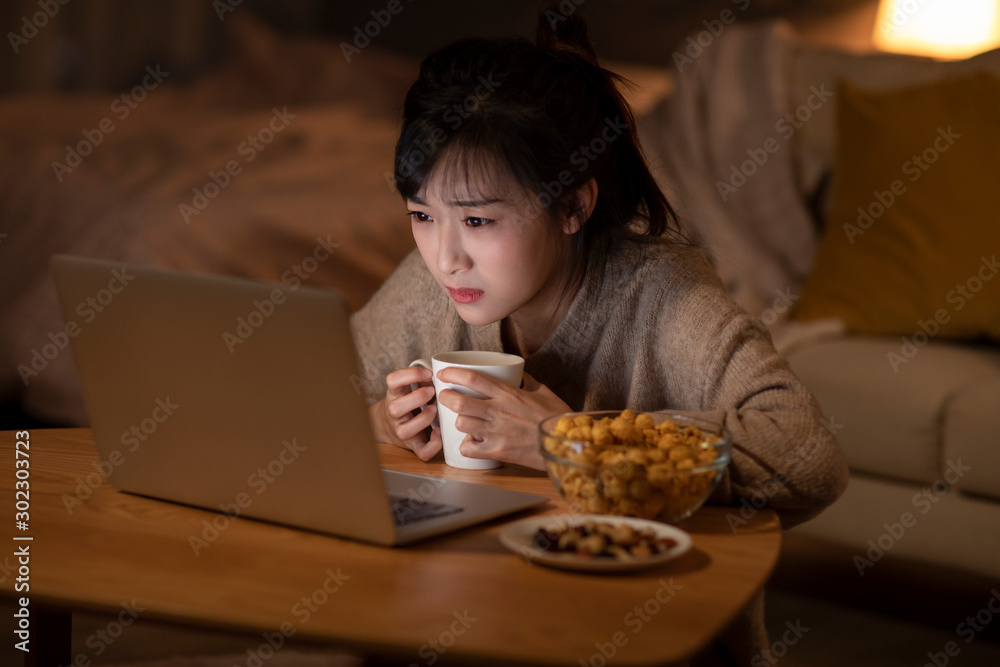 Young Chinese woman watching movie on laptop Young Chinese woman watching movie on laptop