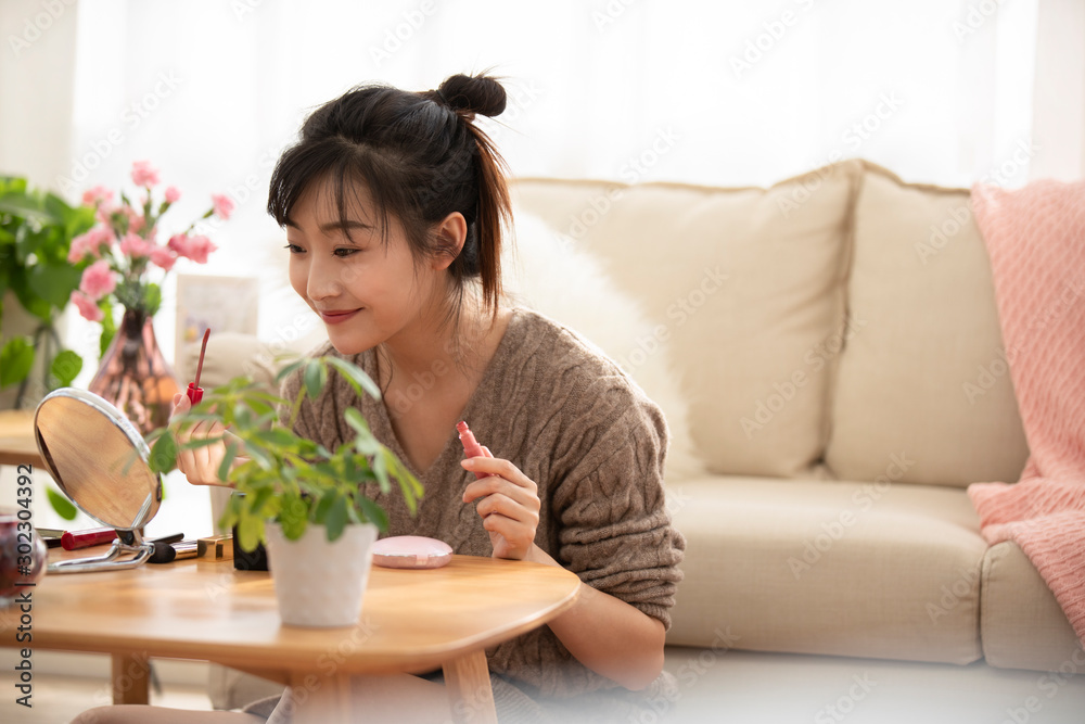 Young Chinese woman applying makeup at home Young Chinese woman applying makeup at home