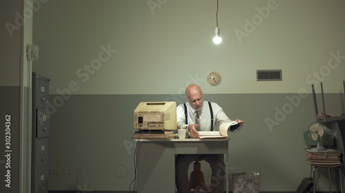 Sad businessman working in a small office photo