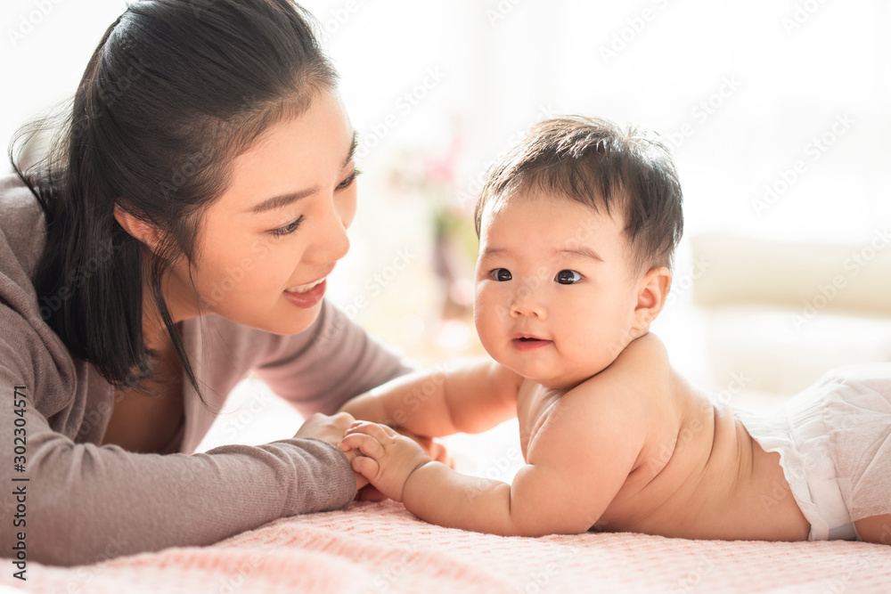 Young Chinese mom taking care of baby girl Young Chinese mom taking care of baby girl