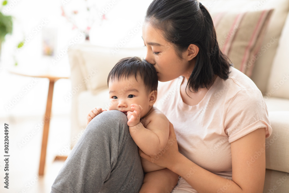 Young Chinese mom playing with her baby girl Young Chinese mom playing with her baby girl