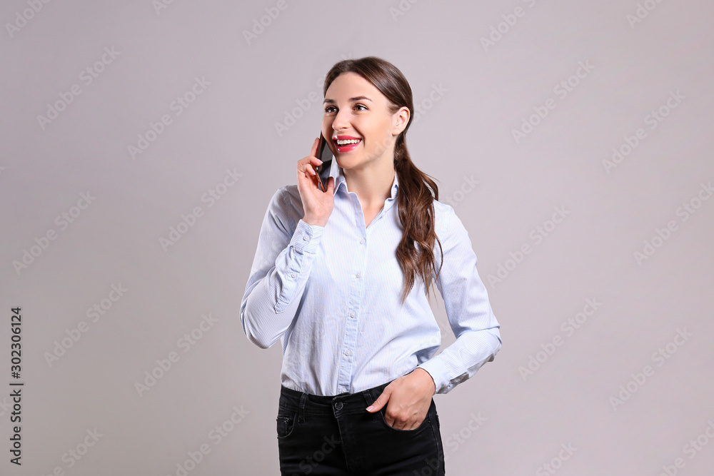 Cheerful attractive young businesswoman in glasses standing and using mobile phone over white background Cheerful attractive young businesswoman in glasses standing and using mobile phone over white background