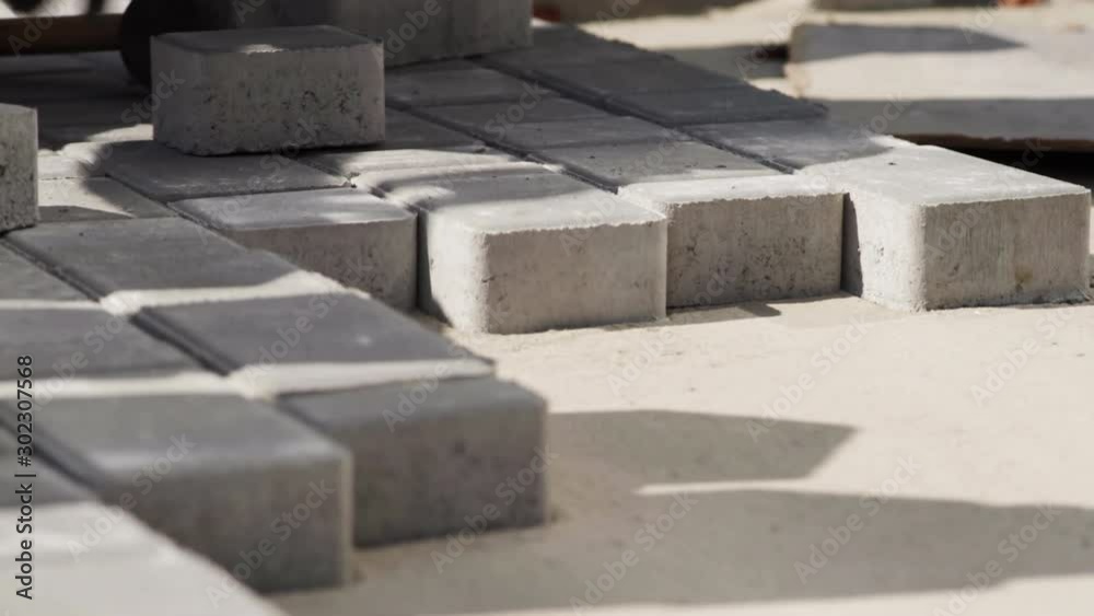 Close-up, Worker in gloves lays paving slabs Close-up, Worker in gloves lays paving slabs