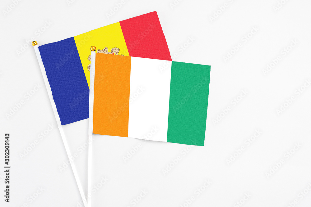 Cote D'Ivoire and Andorra stick flags on white background. High quality fabric, miniature national flag. Peaceful global concept.White floor for copy space. Cote D'Ivoire and Andorra stick flags on white background. High quality fabric, miniature national flag. Peaceful global concept.White floor for copy space.