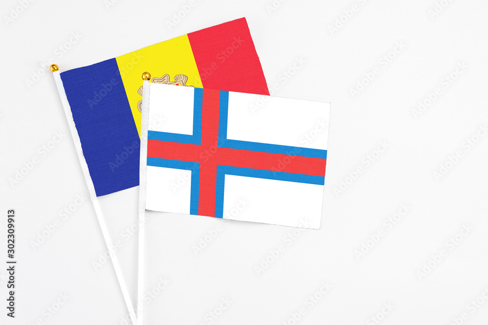 Faroe Islands and Andorra stick flags on white background. High quality fabric, miniature national flag. Peaceful global concept.White floor for copy space.