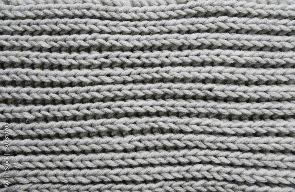 Abstract knitting fabric background. Gray texture background from merino knitted blanket, scandinavian minimalism backdrop with copy space, top view.