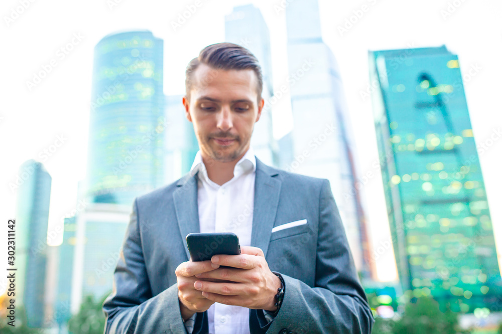 Fototapeta premium Young caucasian man holding smartphone for business work.