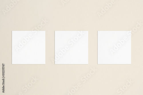 Three empty square white business cards template on bone coloured background. Flat lay, top view. Even and open composition. For branding identity, logo design pitches and marketing. © Sarah