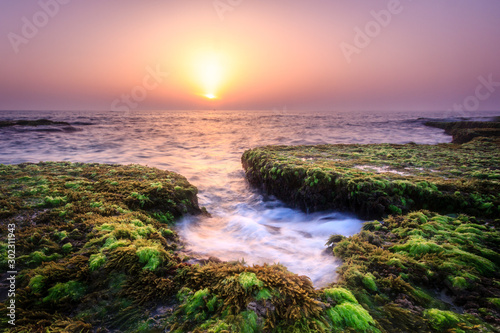sunset on coast of sea with rocks