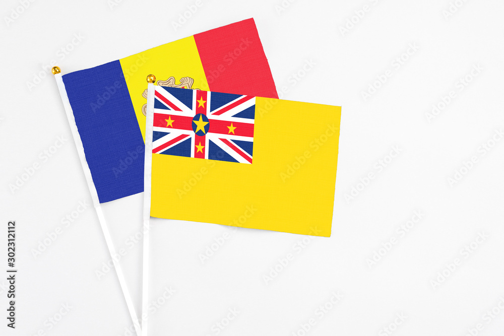 Niue and Andorra stick flags on white background. High quality fabric, miniature national flag. Peaceful global concept.White floor for copy space. Niue and Andorra stick flags on white background. High quality fabric, miniature national flag. Peaceful global concept.White floor for copy space.