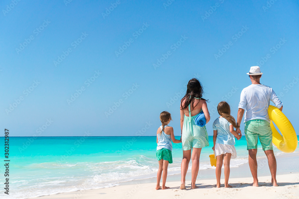 Happy beautiful family of four on the beach