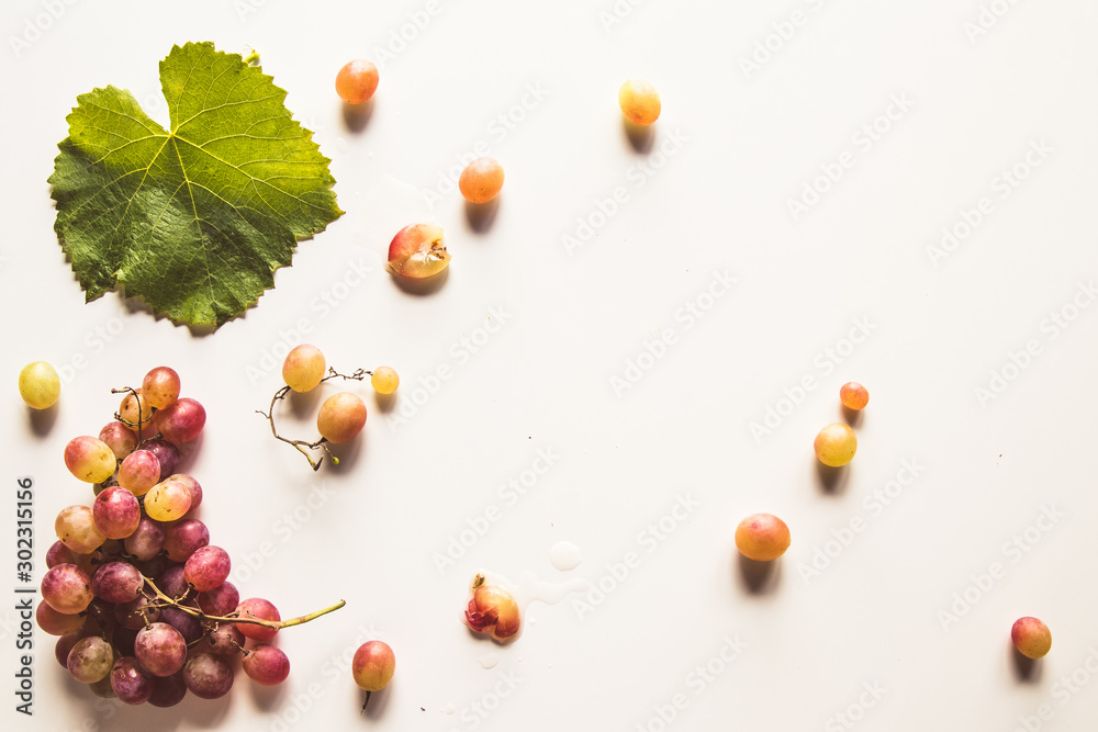 Ripe red grape with leaves isolated on white Ripe red grape with leaves isolated on white