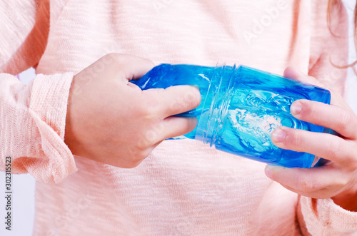 Adorable little girl holding slime toy, worldwide popular self made toy. Kid playing with slime squeeze and stretching it. photo