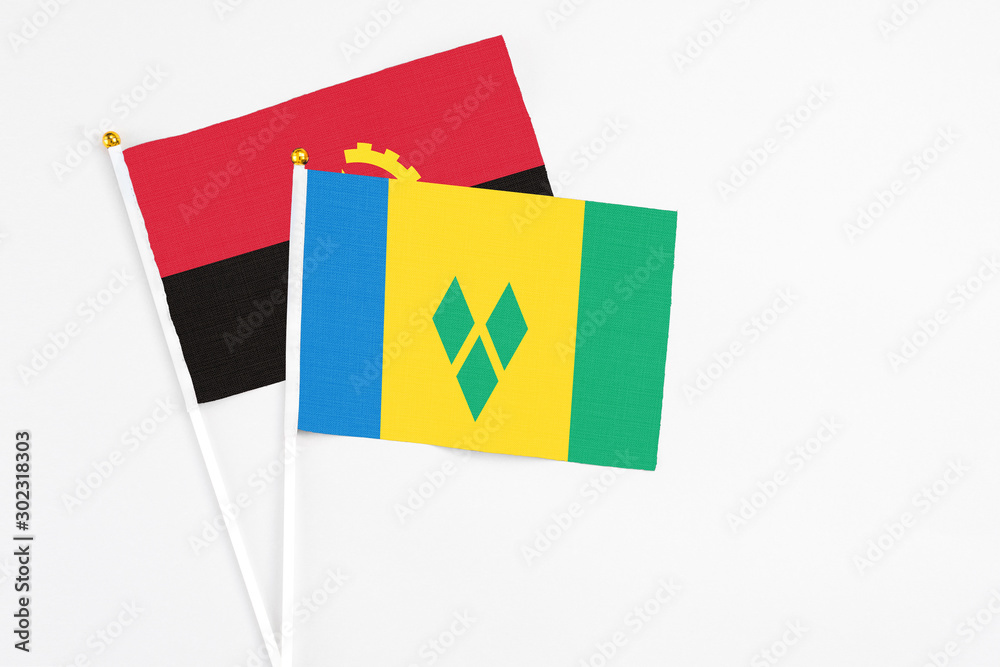 Saint Vincent And The Grenadines and Angola stick flags on white background. High quality fabric, miniature national flag. Peaceful global concept.White floor for copy space. Saint Vincent And The Grenadines and Angola stick flags on white background. High quality fabric, miniature national flag. Peaceful global concept.White floor for copy space.