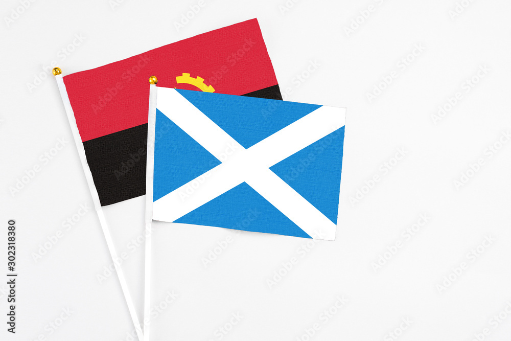 Scotland and Angola stick flags on white background. High quality fabric, miniature national flag. Peaceful global concept.White floor for copy space. Scotland and Angola stick flags on white background. High quality fabric, miniature national flag. Peaceful global concept.White floor for copy space.