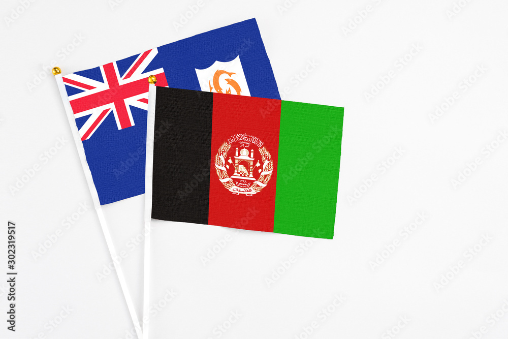 Afghanistan and Anguilla stick flags on white background. High quality fabric, miniature national flag. Peaceful global concept.White floor for copy space.