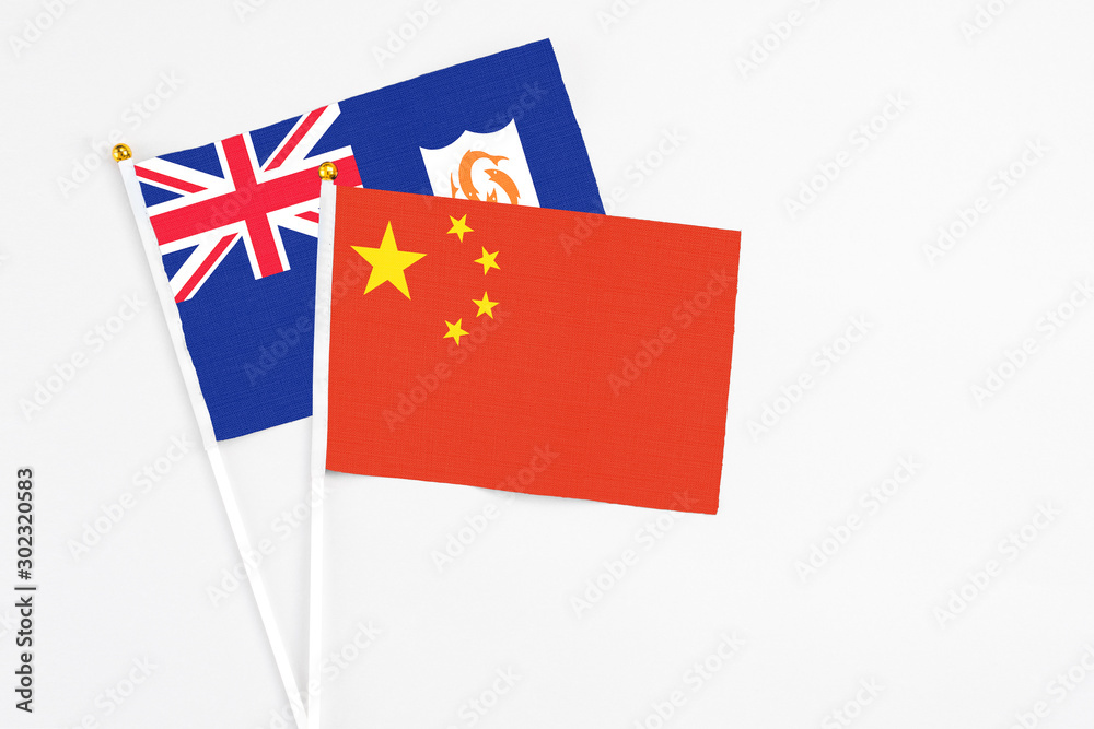 China and Anguilla stick flags on white background. High quality fabric, miniature national flag. Peaceful global concept.White floor for copy space.