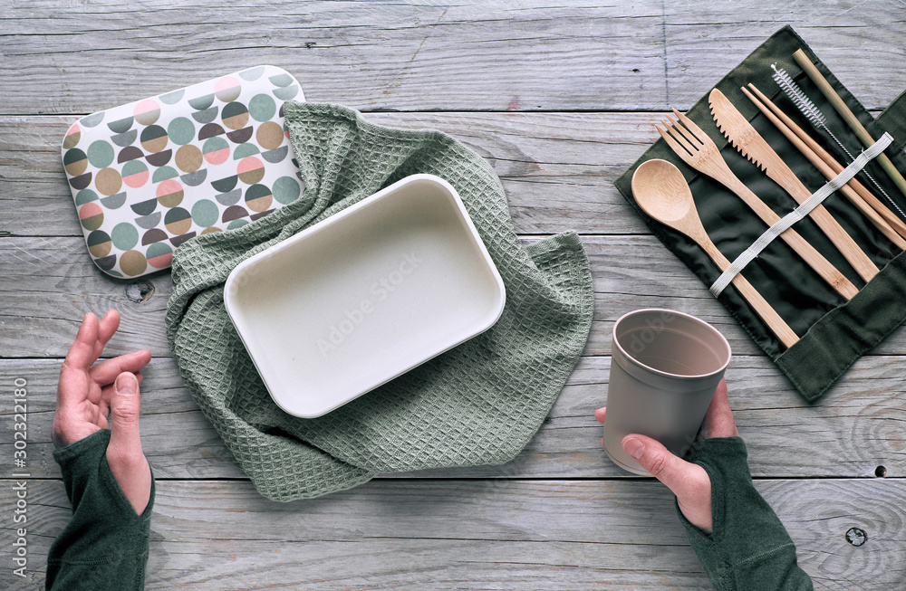 Creative flat lay, zero waste lunch concept with set of reusable wooden cutlery, lunch box, drinking bottle and reusable coffee cup. Sustainable lifestyle top view, flat layout on wood, copy-space. Creative flat lay, zero waste lunch concept with set of reusable wooden cutlery, lunch box, drinking bottle and reusable coffee cup. Sustainable lifestyle top view, flat layout on wood, copy-space.