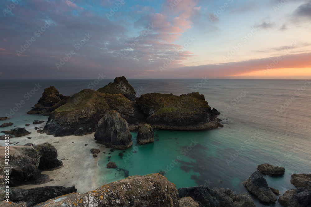 The picturesque Kynance Cove in Cornwall at Sunset which is a National Trust property and a popular tourist attraction shown in a scenic landscape image