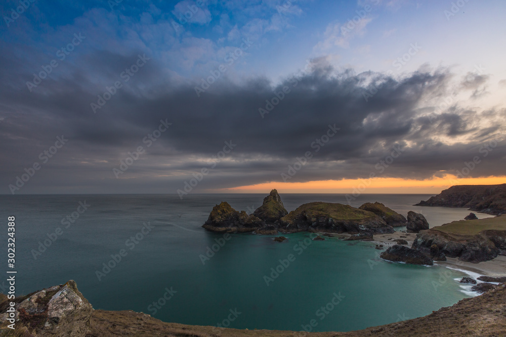 The picturesque Kynance Cove in Cornwall at Sunset which is a National Trust property and a popular tourist attraction shown in a scenic landscape image