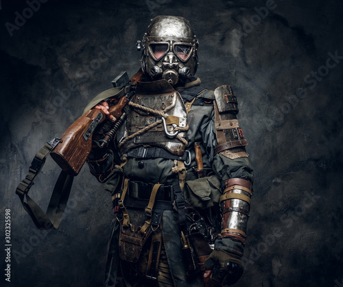 Portrait of a man in interesting costume of dark apocalypse warrior at photo studio.