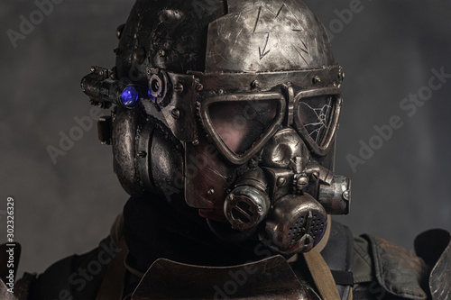 Close up photo shoot of man in helmet with gas mask and small flash light on side.