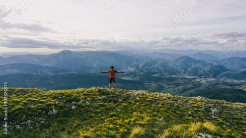 Successful hiker outstretched arms at seaside mountain top cliff edge