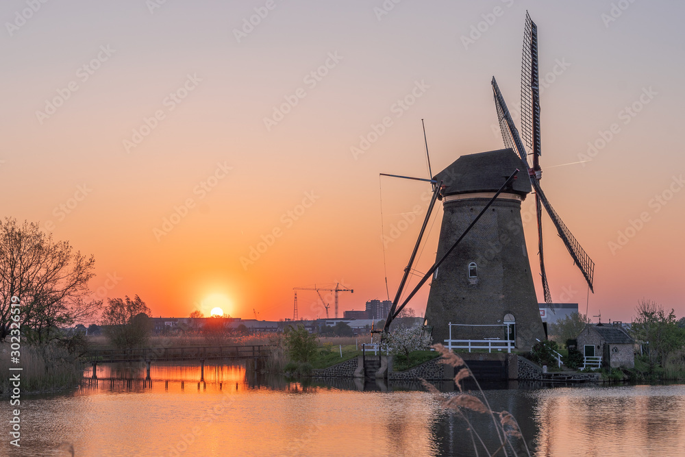 Golden red sunset cast on Windmills in Kinderdijk near Rotterdam, Netherlands