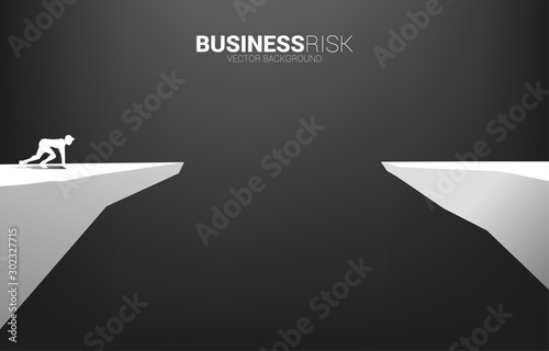 silhouette of businessman ready to run to jumping over the gap. concept of business challenge risk.