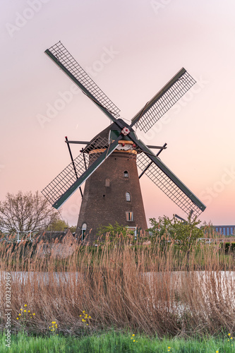 Golden red sunset cast on Windmills in Kinderdijk near Rotterdam, Netherlands