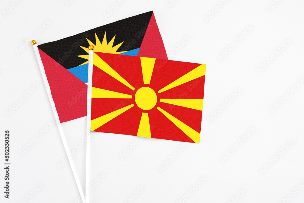 Macedonia and Antigua and Barbuda stick flags on white background. High quality fabric, miniature national flag. Peaceful global concept.White floor for copy space.