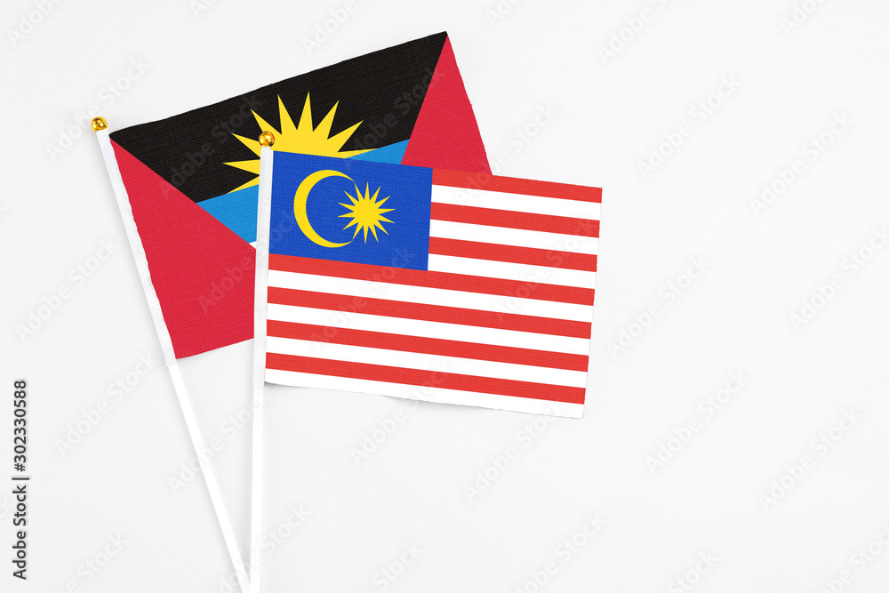 Malaysia and Antigua and Barbuda stick flags on white background. High quality fabric, miniature national flag. Peaceful global concept.White floor for copy space. Malaysia and Antigua and Barbuda stick flags on white background. High quality fabric, miniature national flag. Peaceful global concept.White floor for copy space.
