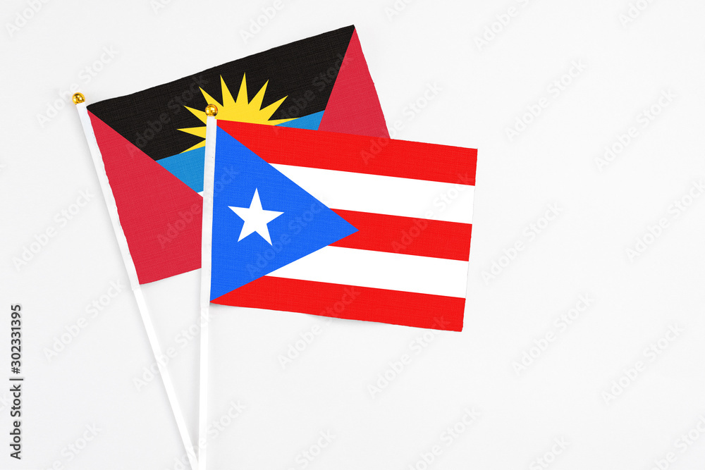 Puerto Rico and Antigua and Barbuda stick flags on white background. High quality fabric, miniature national flag. Peaceful global concept.White floor for copy space. Puerto Rico and Antigua and Barbuda stick flags on white background. High quality fabric, miniature national flag. Peaceful global concept.White floor for copy space.