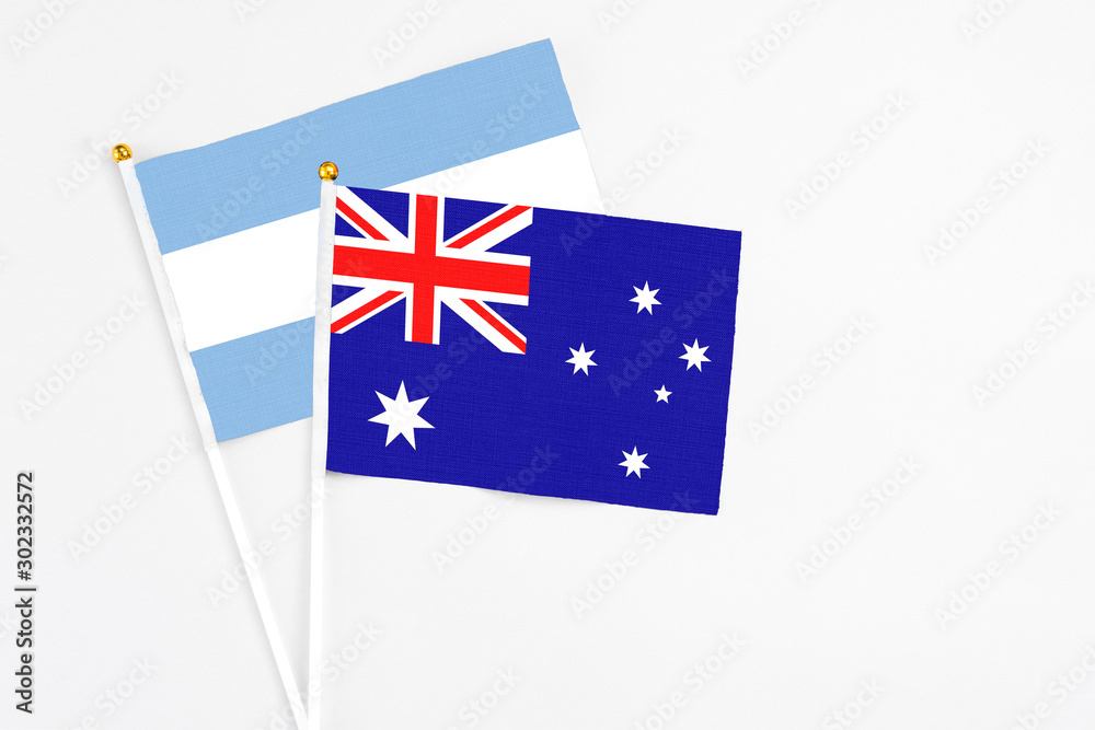 Fototapeta premium Australia and Argentina stick flags on white background. High quality fabric, miniature national flag. Peaceful global concept.White floor for copy space.