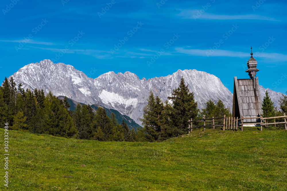 landscape in alps, meadow with wooden chapel in the wetterstein mountains, tyrol